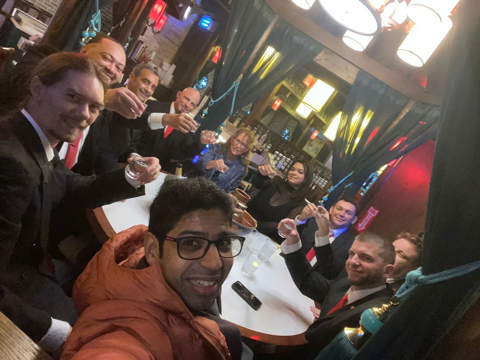 A group of people are sitting around a table toasting