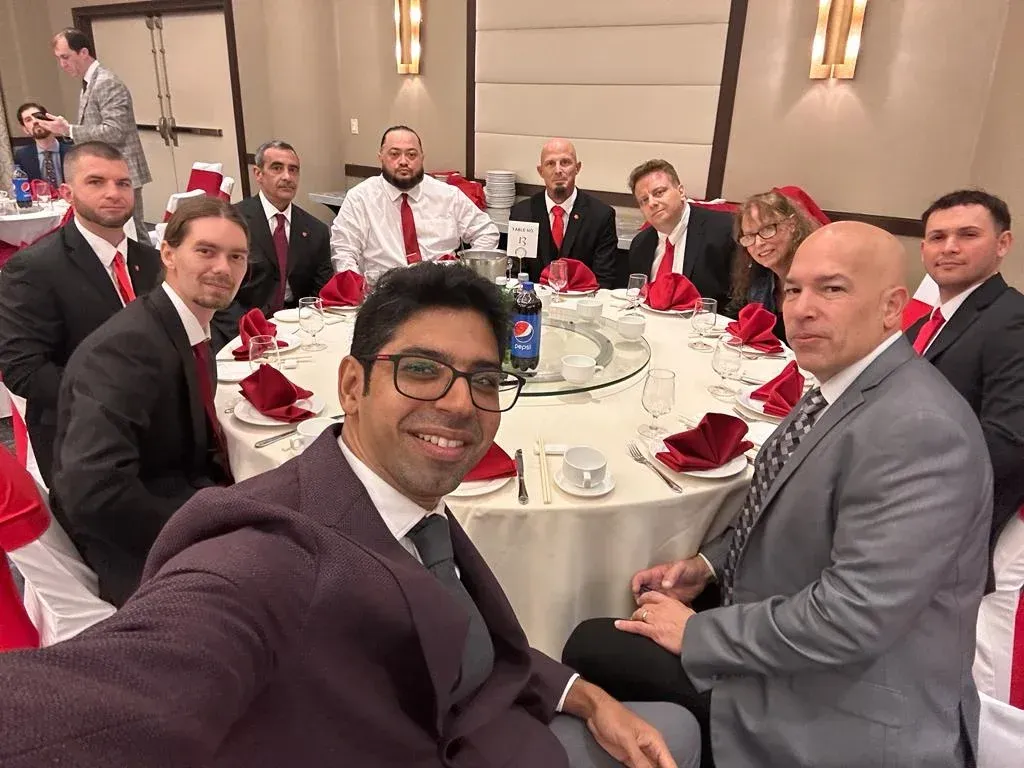 A group of men in suits and ties are sitting around a table.