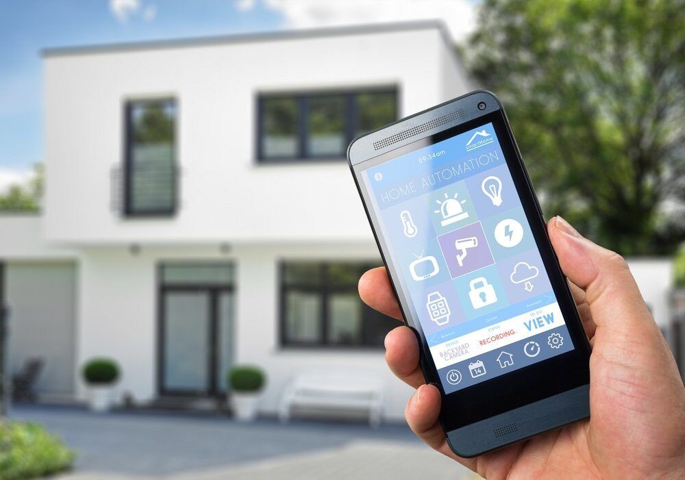A Person is Holding a Smart Phone in Front of a House — Audiomation in Nabiac, NSW
