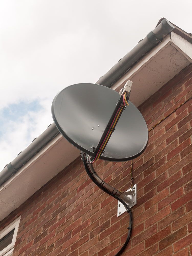 A Satellite Dish is Mounted on the Side of a Brick Building — Audiomation in Nabiac, NSW