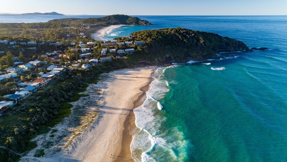 An Aerial View of a Beach and Ocean With Waves Crashing on the Shore — Audiomation in Pacific Palms, NSW
