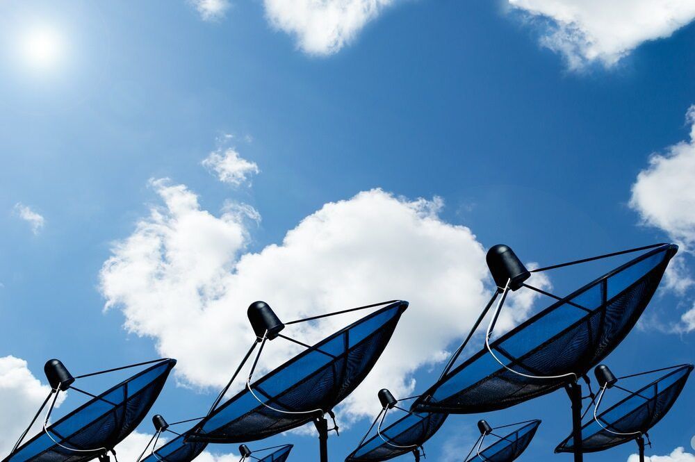 A Row of Satellite Dishes Against a Blue Sky With Clouds — Audiomation in Pacific Palms, NSW