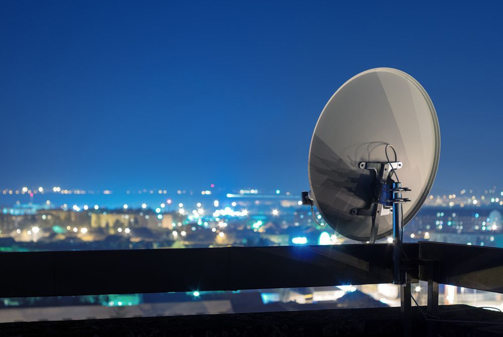 A Satellite Dish is Sitting on Top of a Balcony Overlooking a City at Night — Audiomation in Wingham, NSW