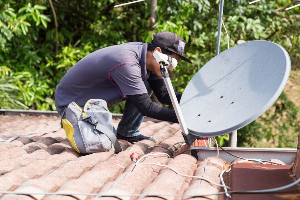 A Man is Installing a Satellite Dish on the Roof of a House — Audiomation in Pacific Palms, NSW