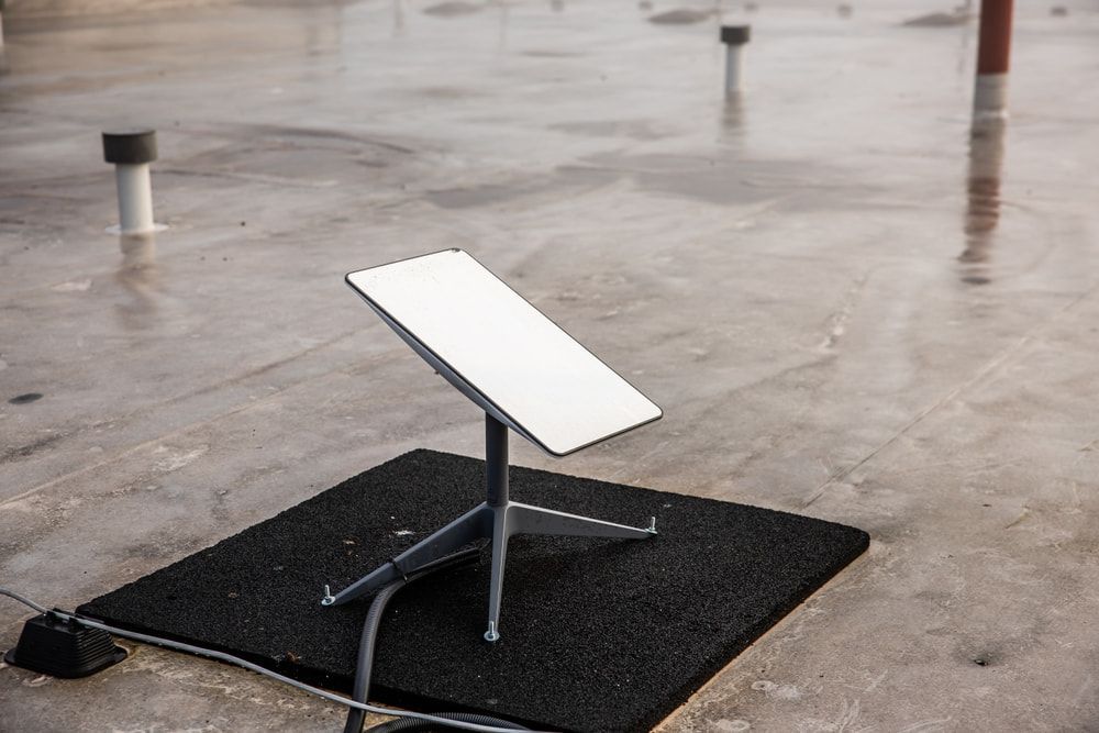 A Satellite Dish is Sitting on Top of a Black Mat on a Roof — Audiomation in Pacific Palms, NSW