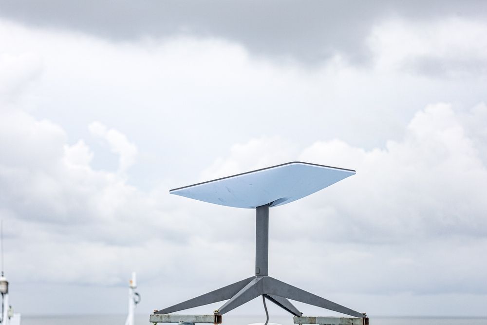Satellite dish, angled, on a stand against a cloudy sky. — Audiomation in Taree, NSW