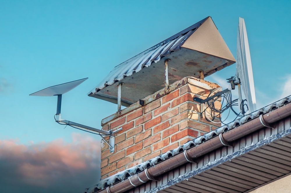 A Brick Chimney With a Satellite Dish on Top of It — Audiomation in Taree, NSW