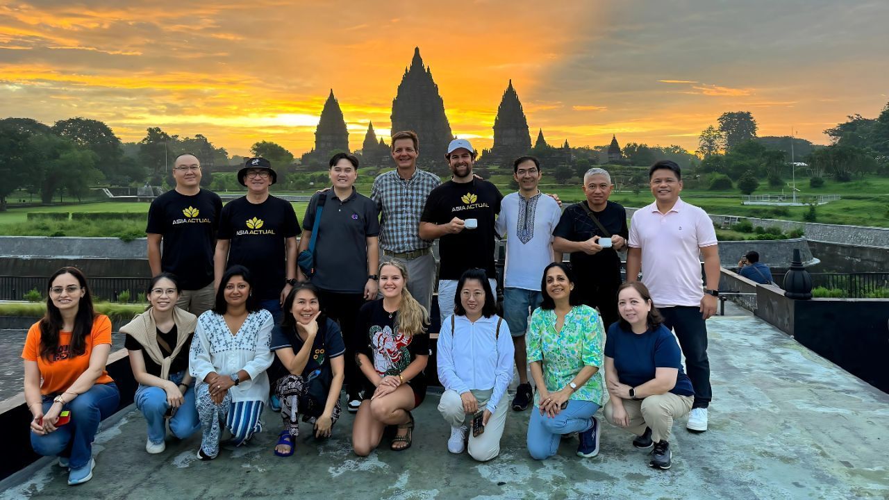 a foreginer enjoy tour in prambanana with sunset view background