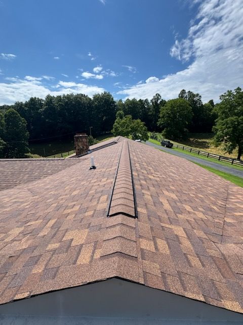 Close-up of overlapping dark gray roof shingles in a diagonal pattern