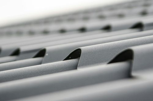 Rows of gray metal roof panels with evenly spaced raised seams