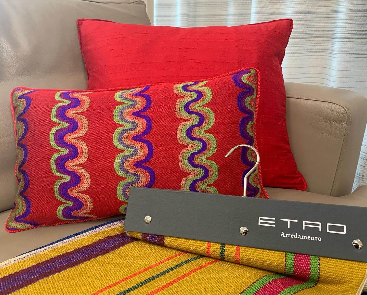 Un divano con cuscini colorati e un cartello con scritto etro