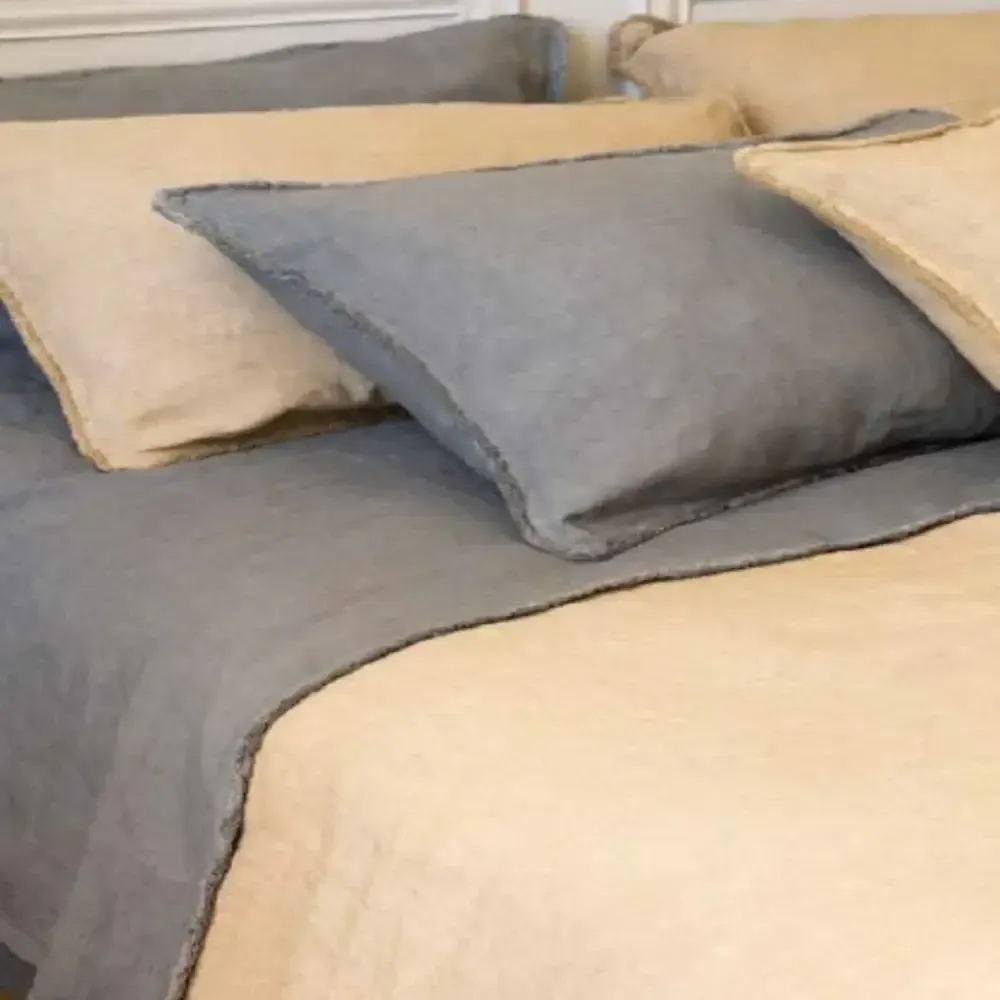 Un letto con una coperta e dei cuscini sopra