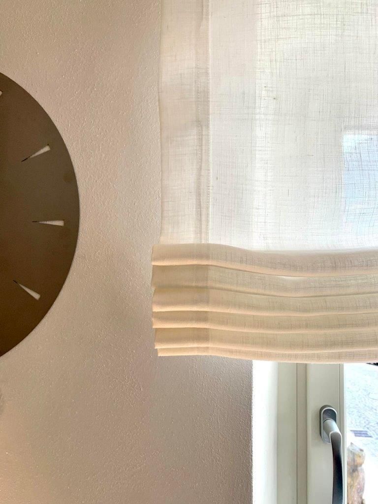 Un orologio è appeso al muro vicino a una finestra.