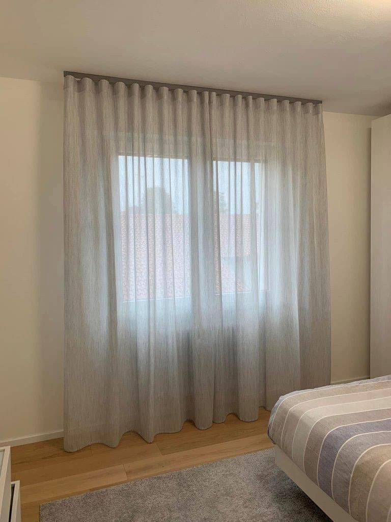 Una camera da letto con un letto e una finestra con le tende.