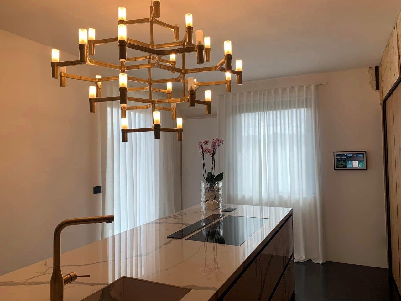 Una cucina con una grande isola e un lampadario appeso al soffitto.