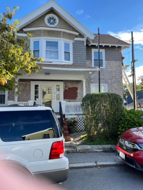 A white suv is parked in front of a house