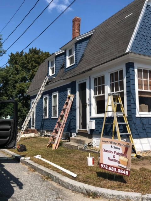 A truck is parked in front of a house that is being painted