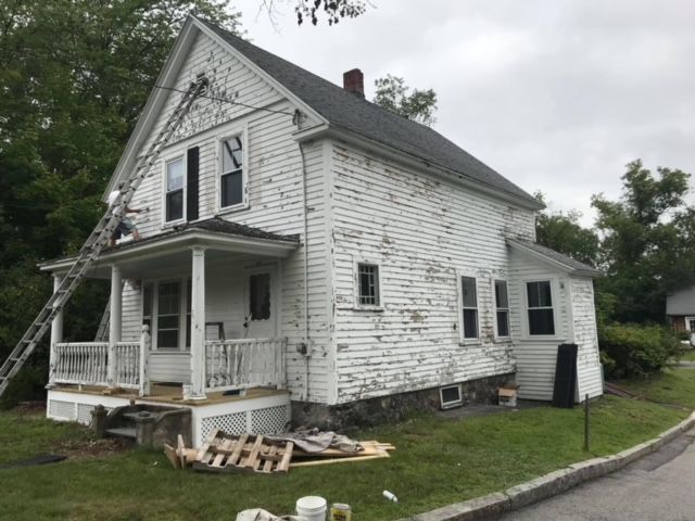 A white house with a ladder on the side of it