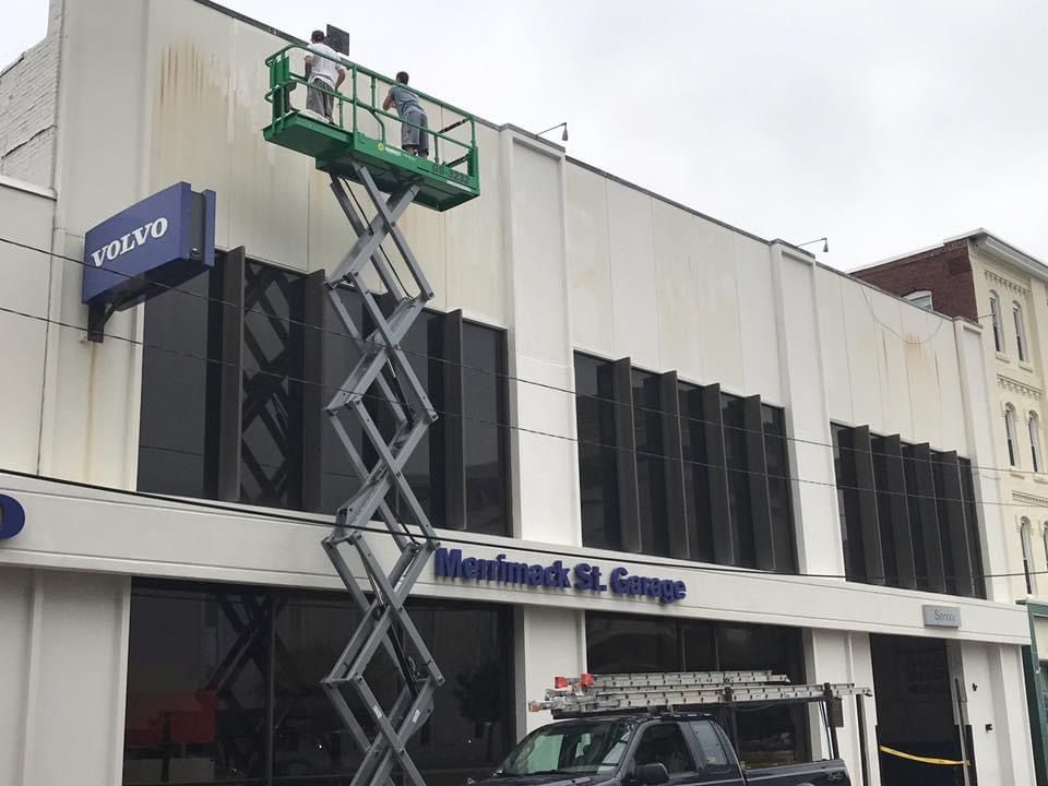 A volvo sign is hanging from the side of a building.