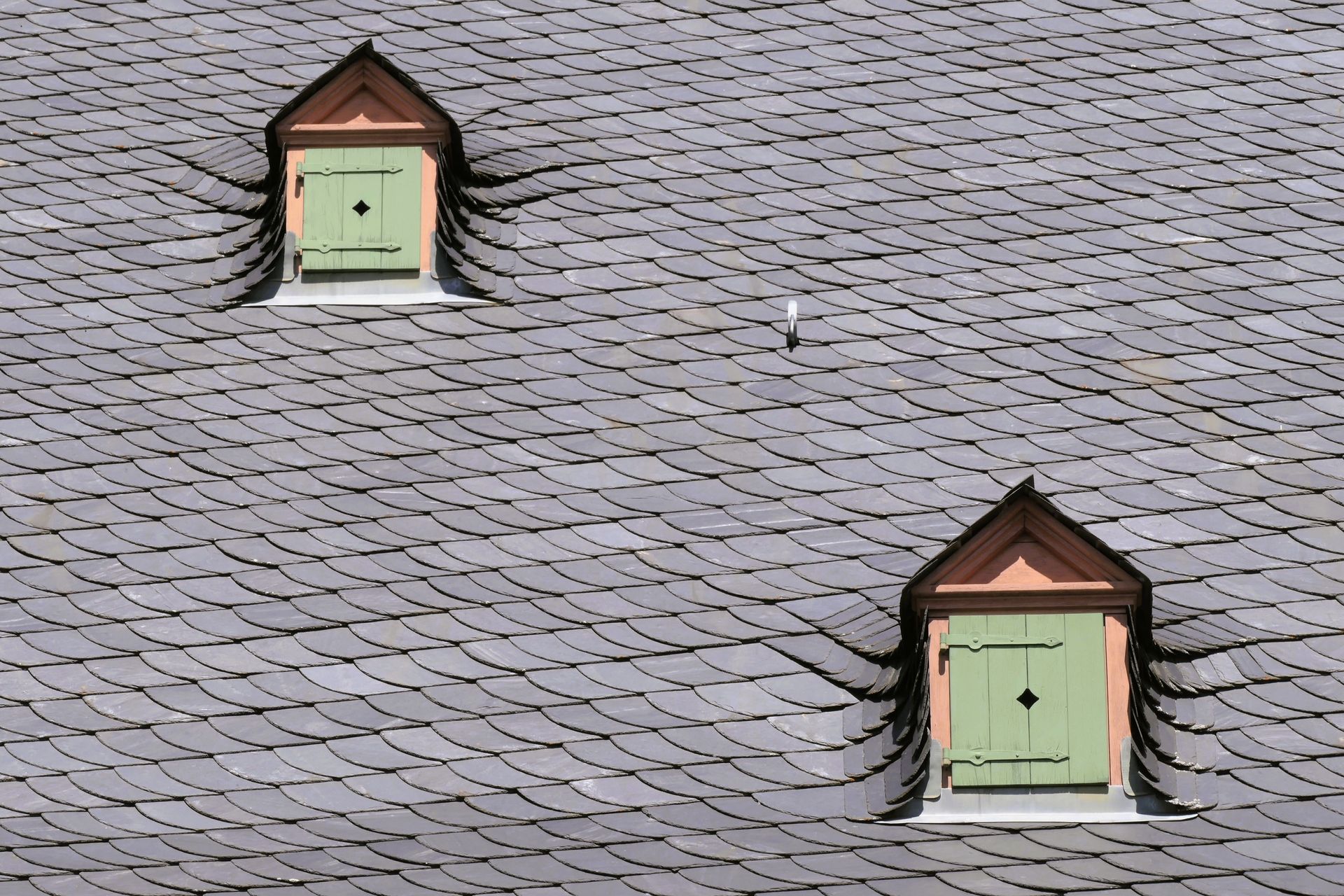 Two small dormer windows on a gray shingled roof