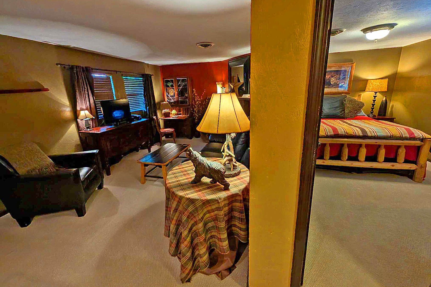 A living room with a table and chairs and a bed
