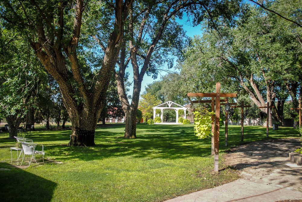 There is a gazebo in the middle of the park surrounded by trees.