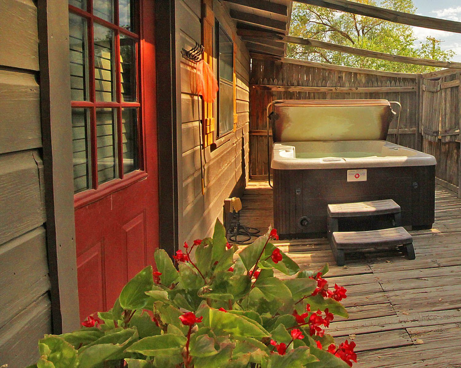 A hot tub is sitting on a deck outside of a house