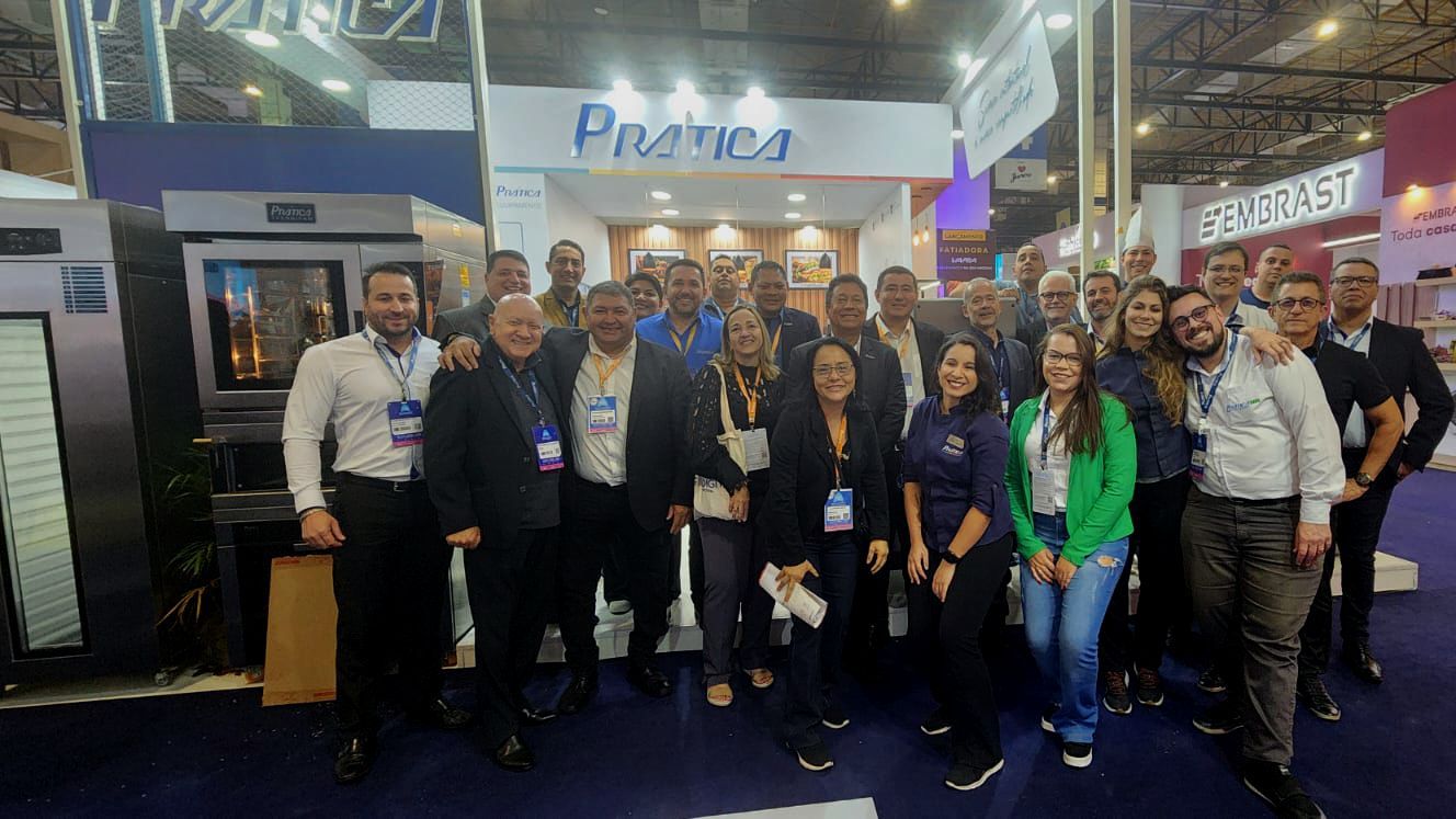 Um grupo de pessoas está posando para uma foto em uma convenção.