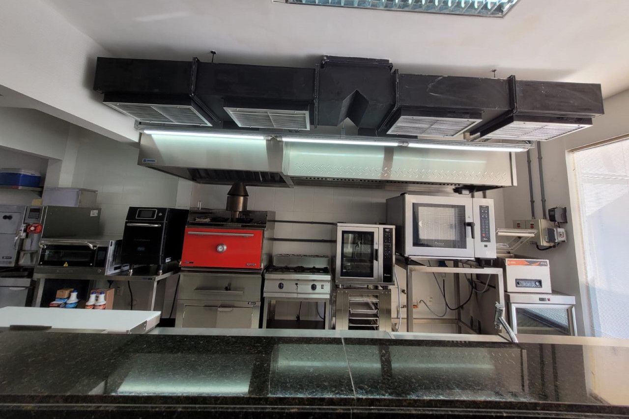 Uma cozinha com muitos eletrodomésticos, incluindo um forno de micro-ondas