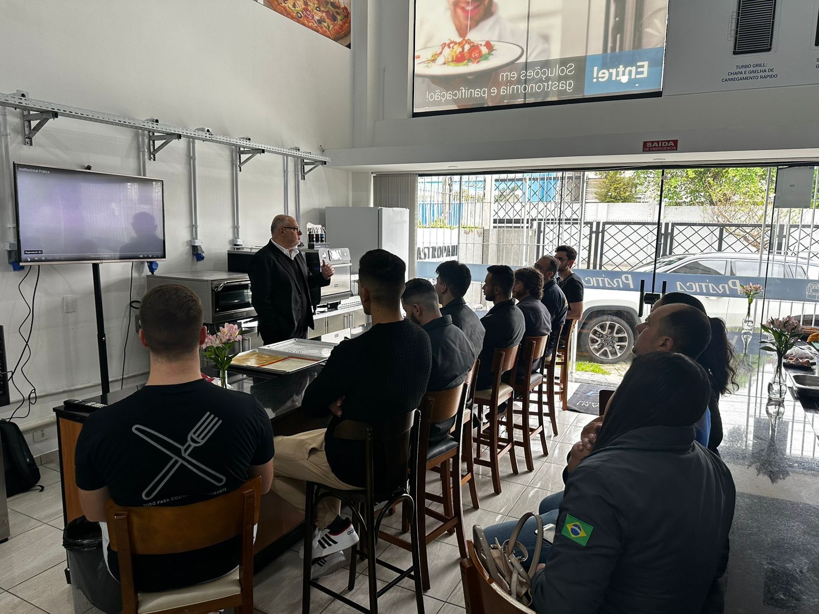 Um grupo de pessoas está sentado em um restaurante assistindo a uma apresentação.