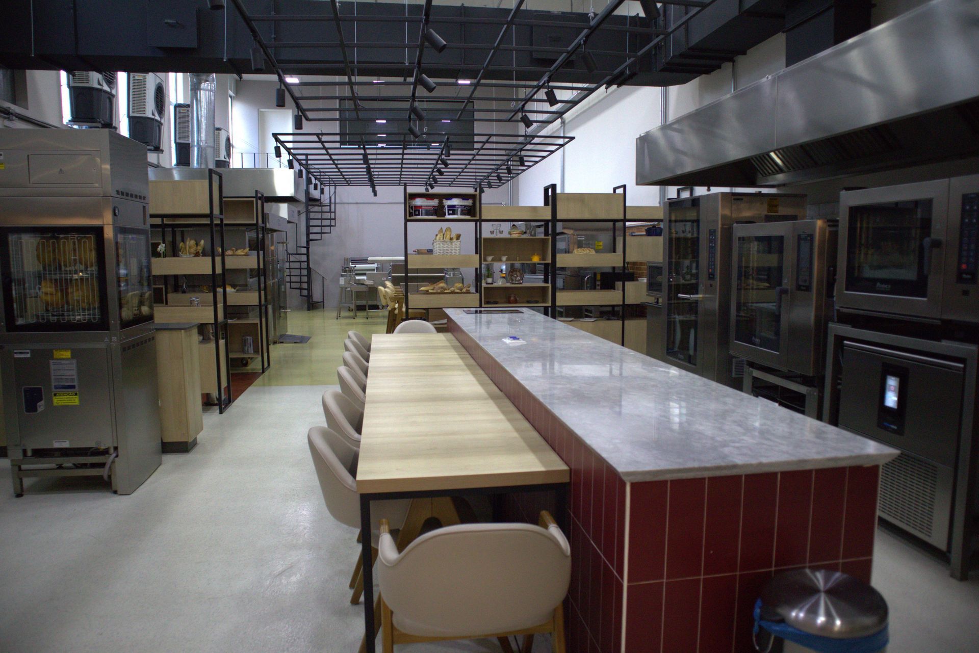 Uma cozinha grande com uma mesa longa e cadeiras.
