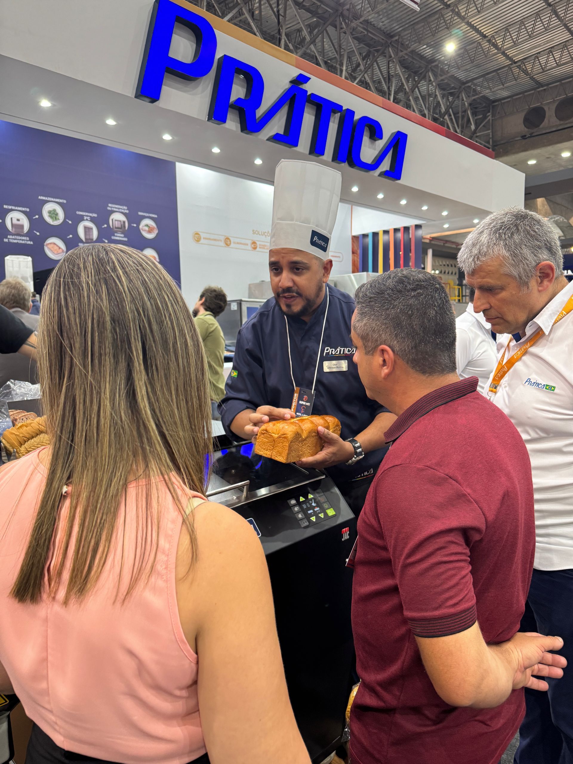 Um chef uniformizado apresenta comida a um grupo em uma barraca de 