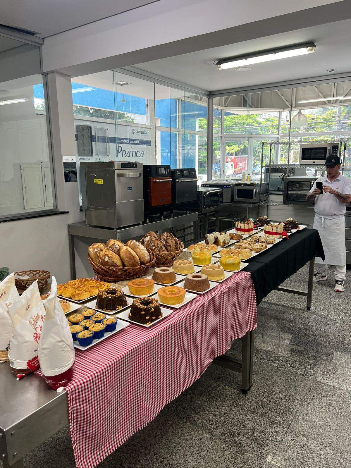 Um homem está de pé em frente a uma mesa cheia de comida.