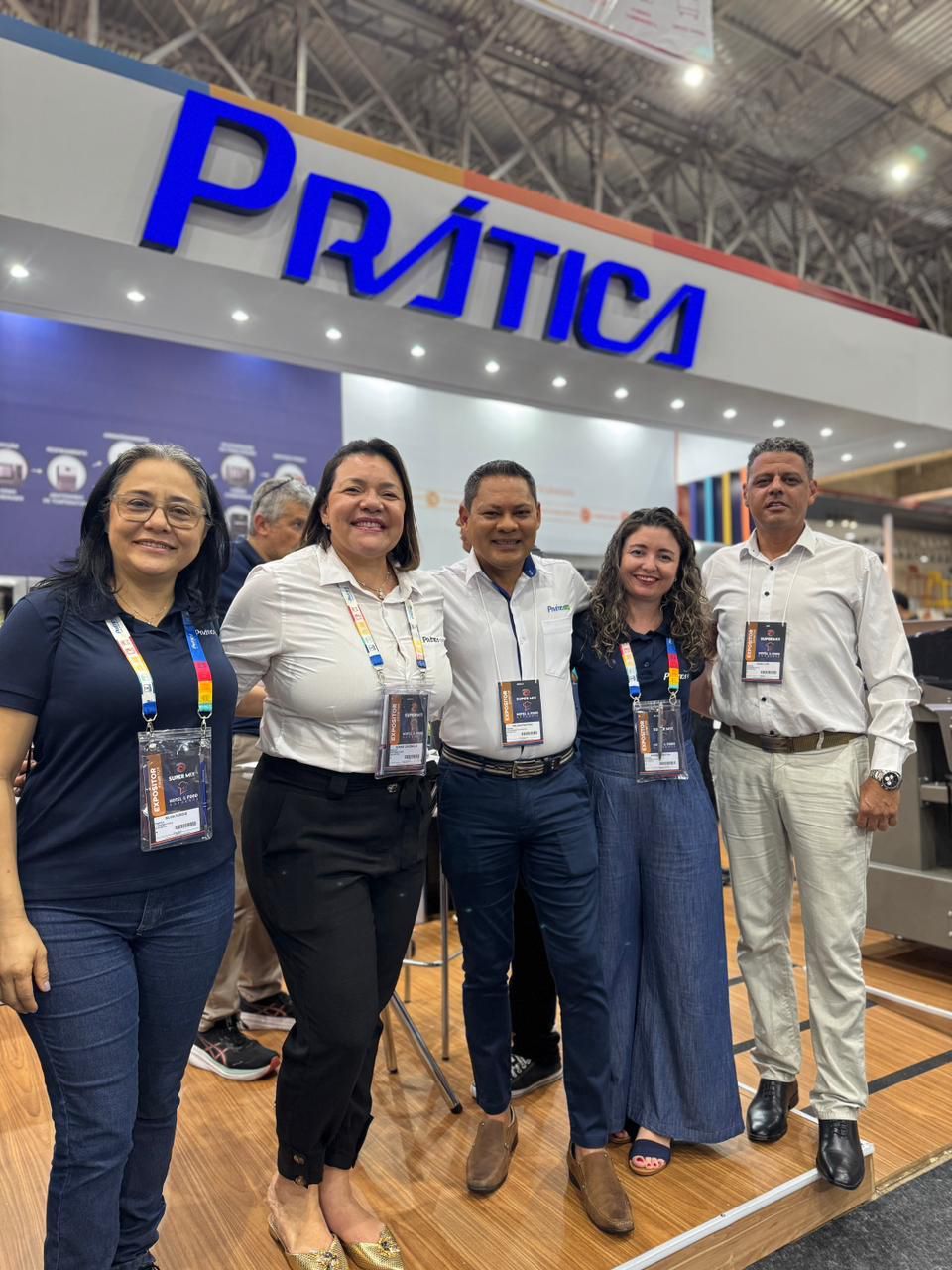 Grupo de pessoas posando em frente a uma placa com a palavra 