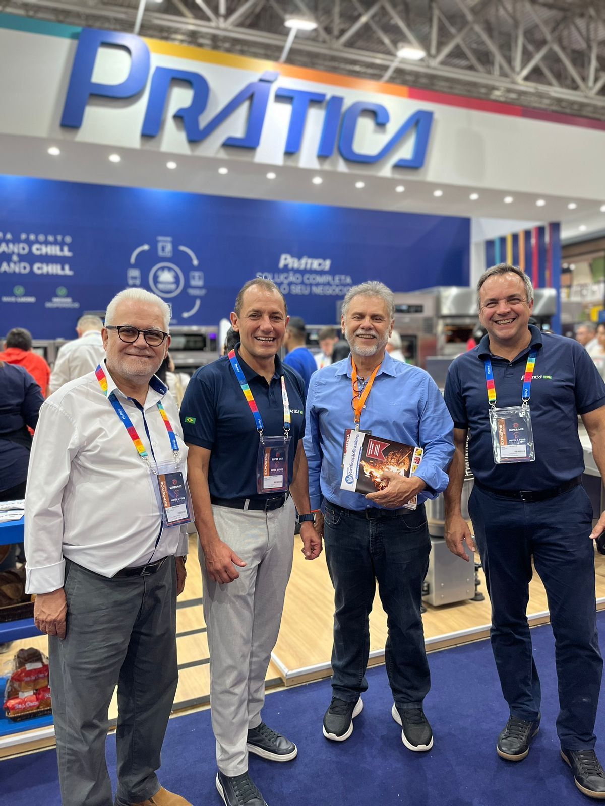 Um grupo de homens está posando para uma foto em frente a uma placa de prática.