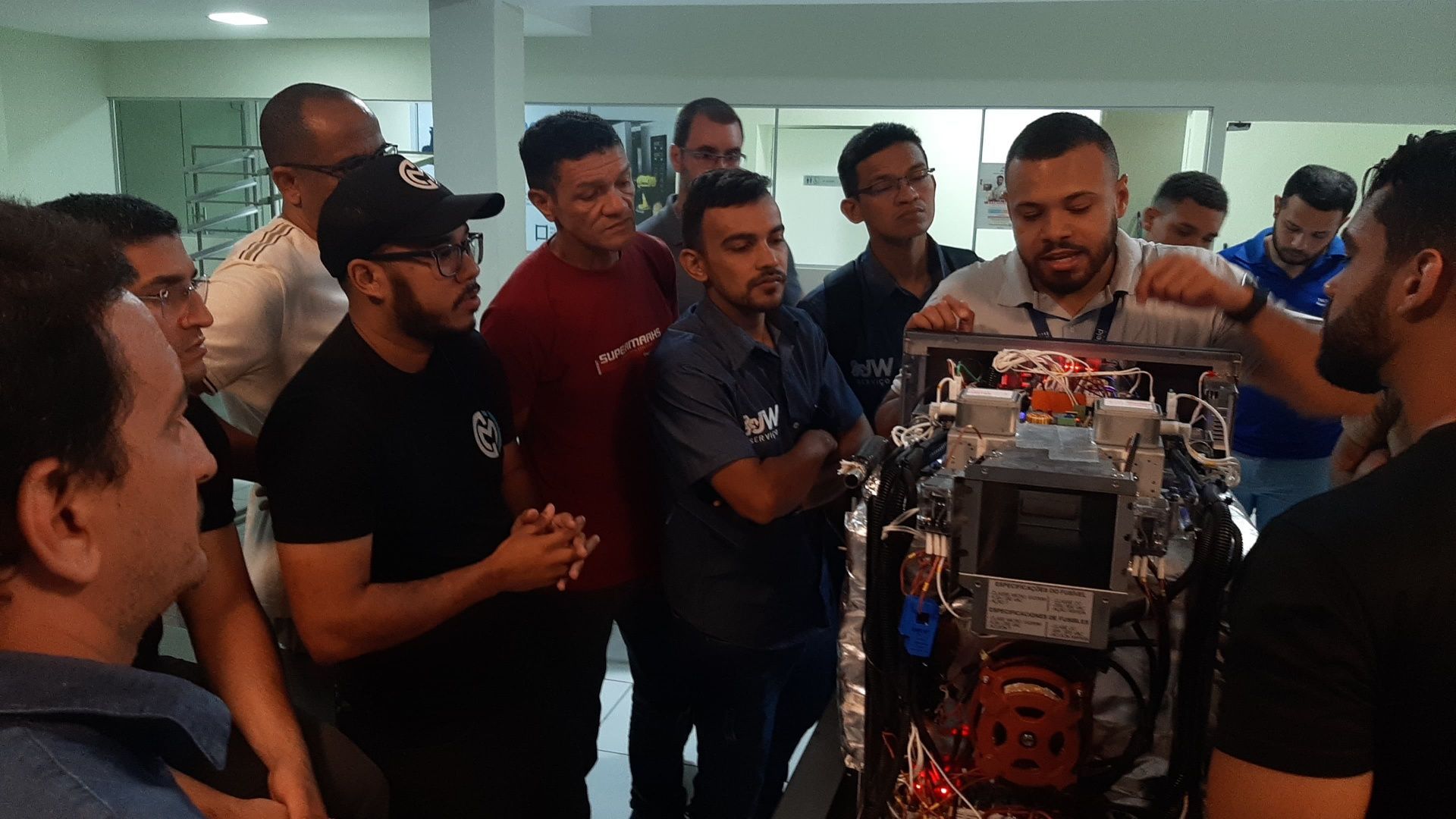 Um grupo de homens está olhando para uma máquina em uma sala.