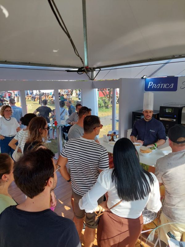 Um grupo de pessoas em pé na frente de uma placa que diz pratika