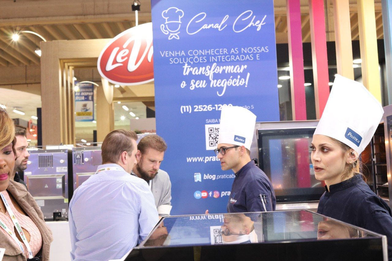Um grupo de pessoas está em frente a uma placa que diz canal chef