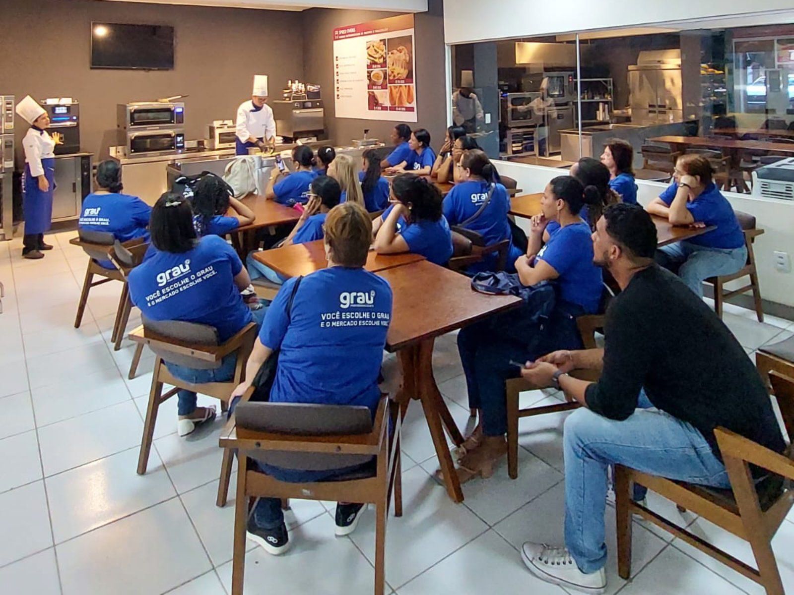 Um grupo de pessoas está sentado em mesas em um restaurante.