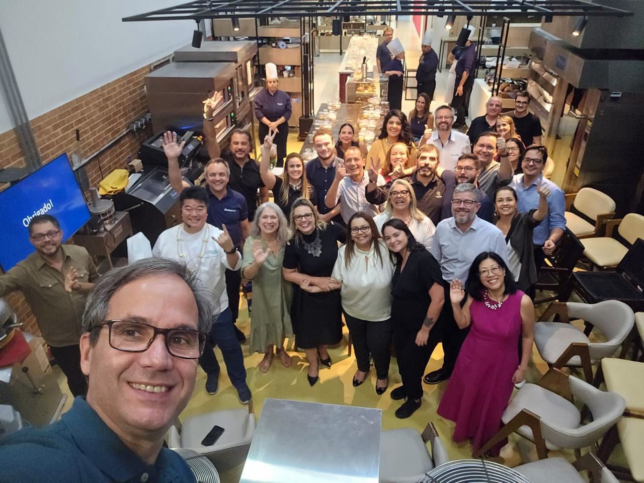 Um grupo de pessoas está posando para uma foto em uma sala.