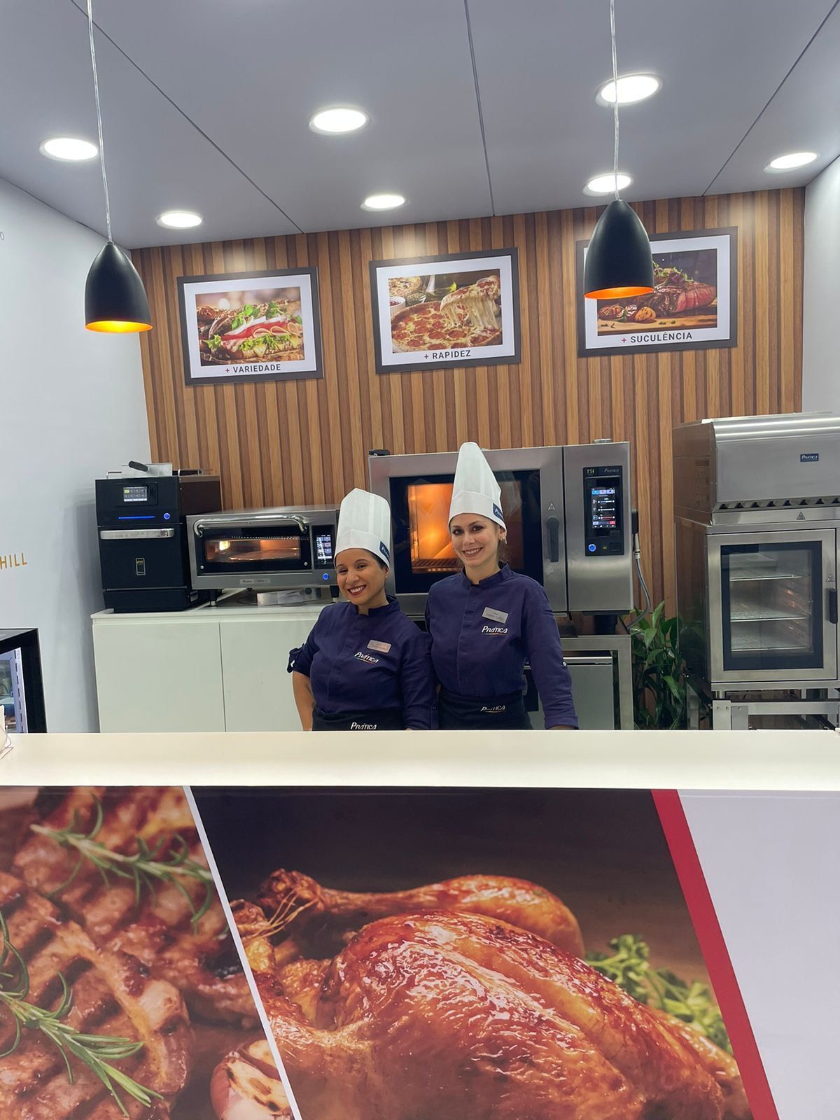 Dois chefs em pé atrás de um balcão em um restaurante