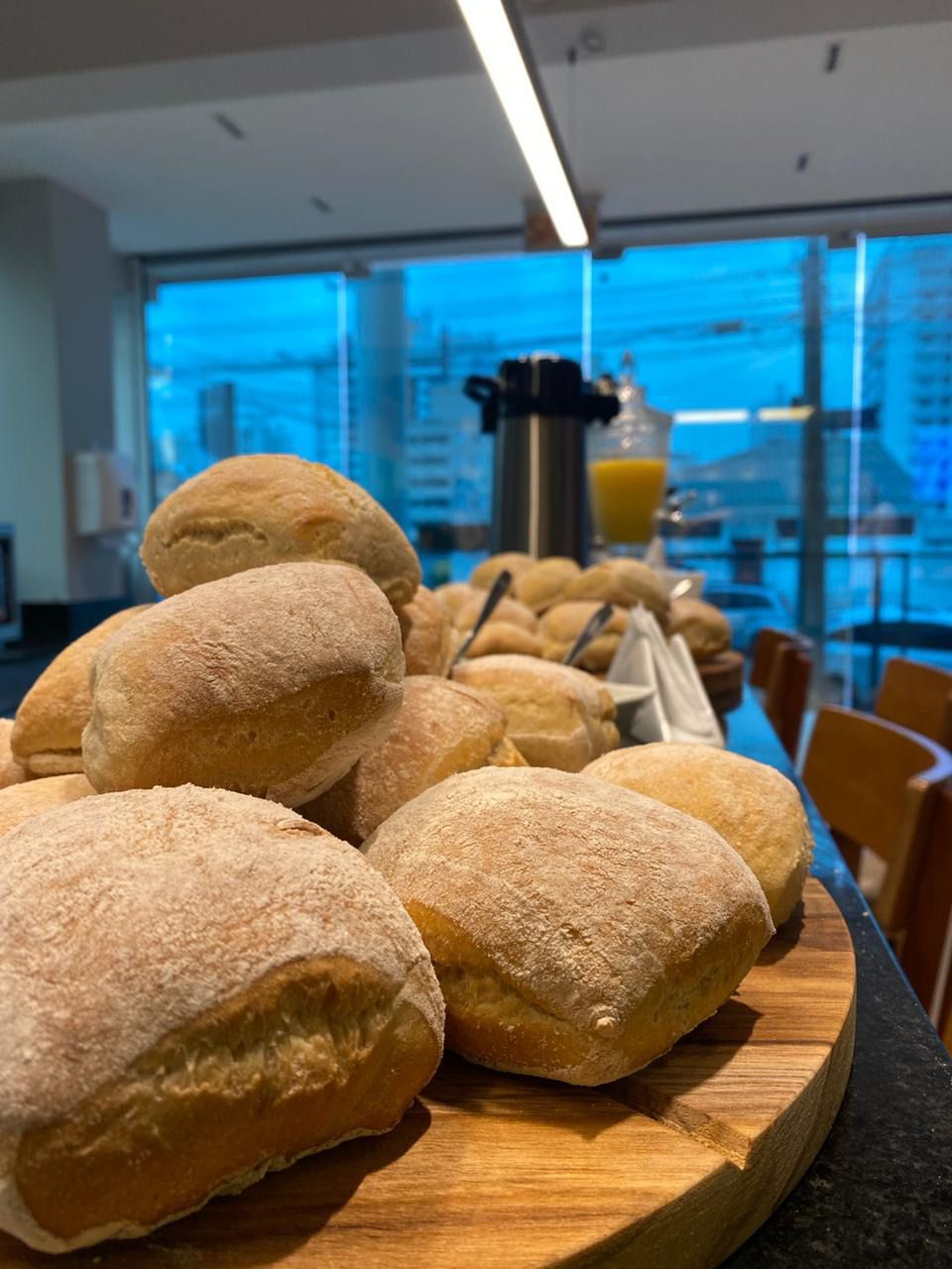 Um monte de pãezinhos estão em uma tábua de corte de madeira