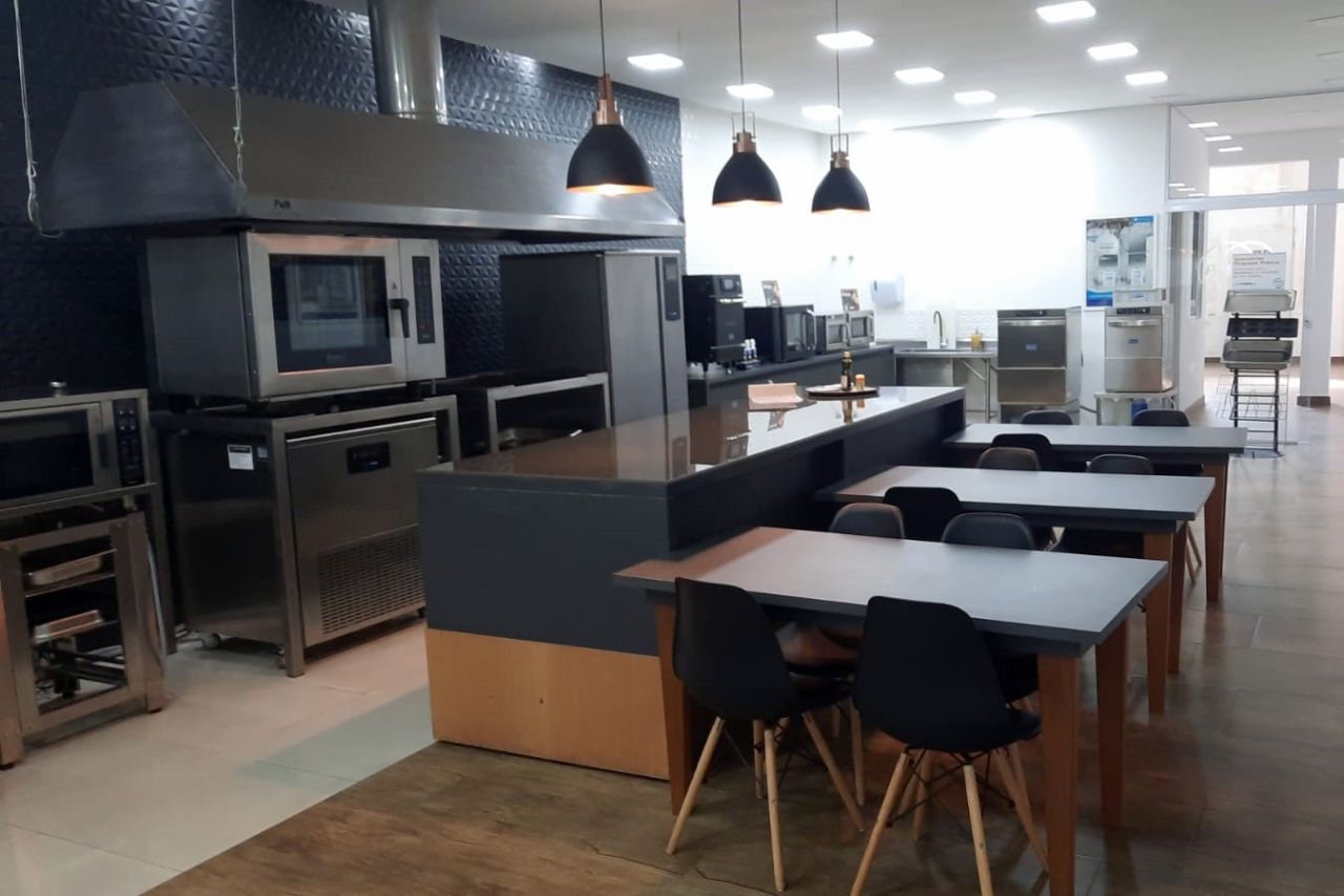 Uma cozinha com muitas mesas e cadeiras