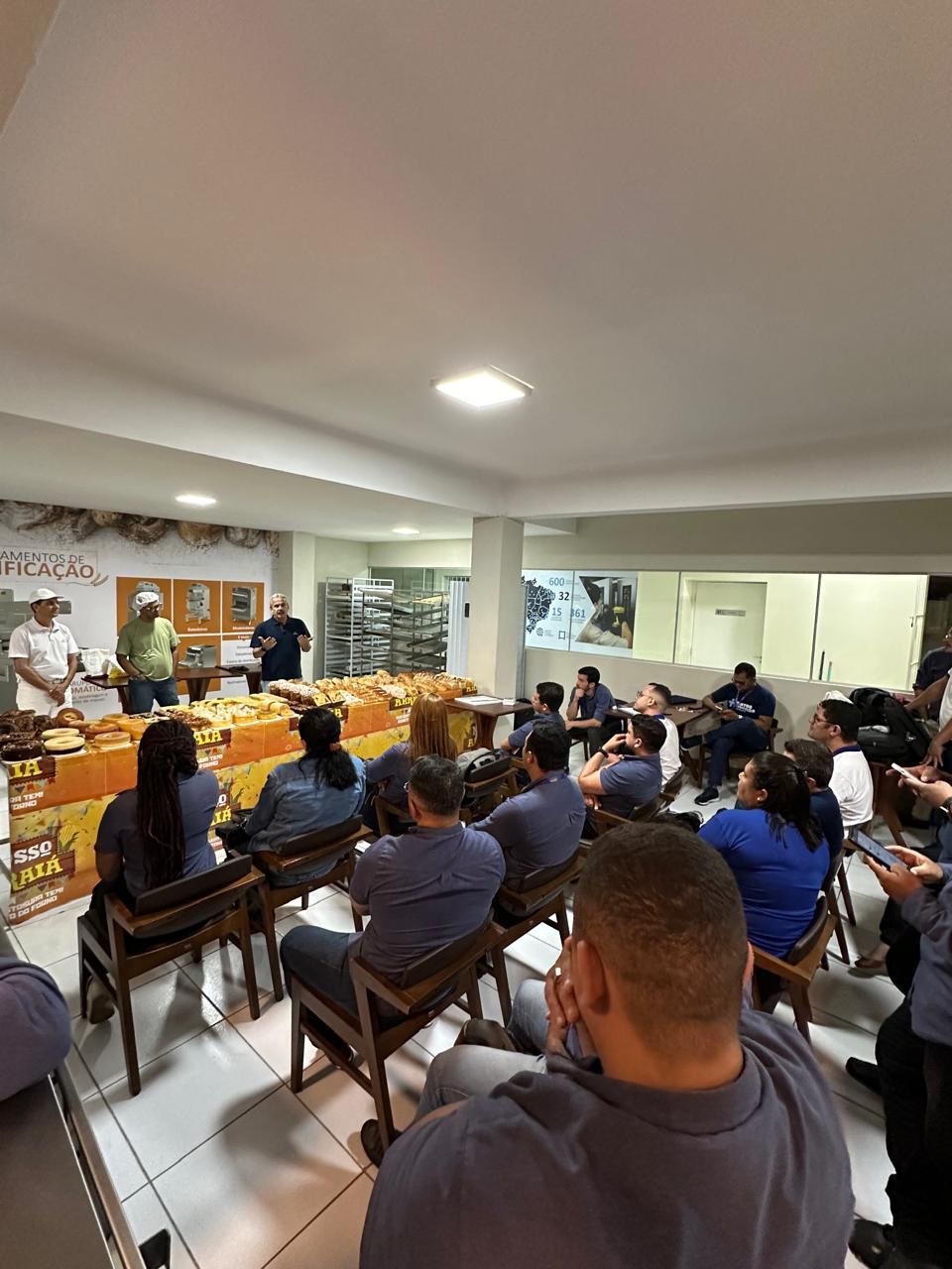 Um grupo de pessoas está sentado em cadeiras em uma sala.
