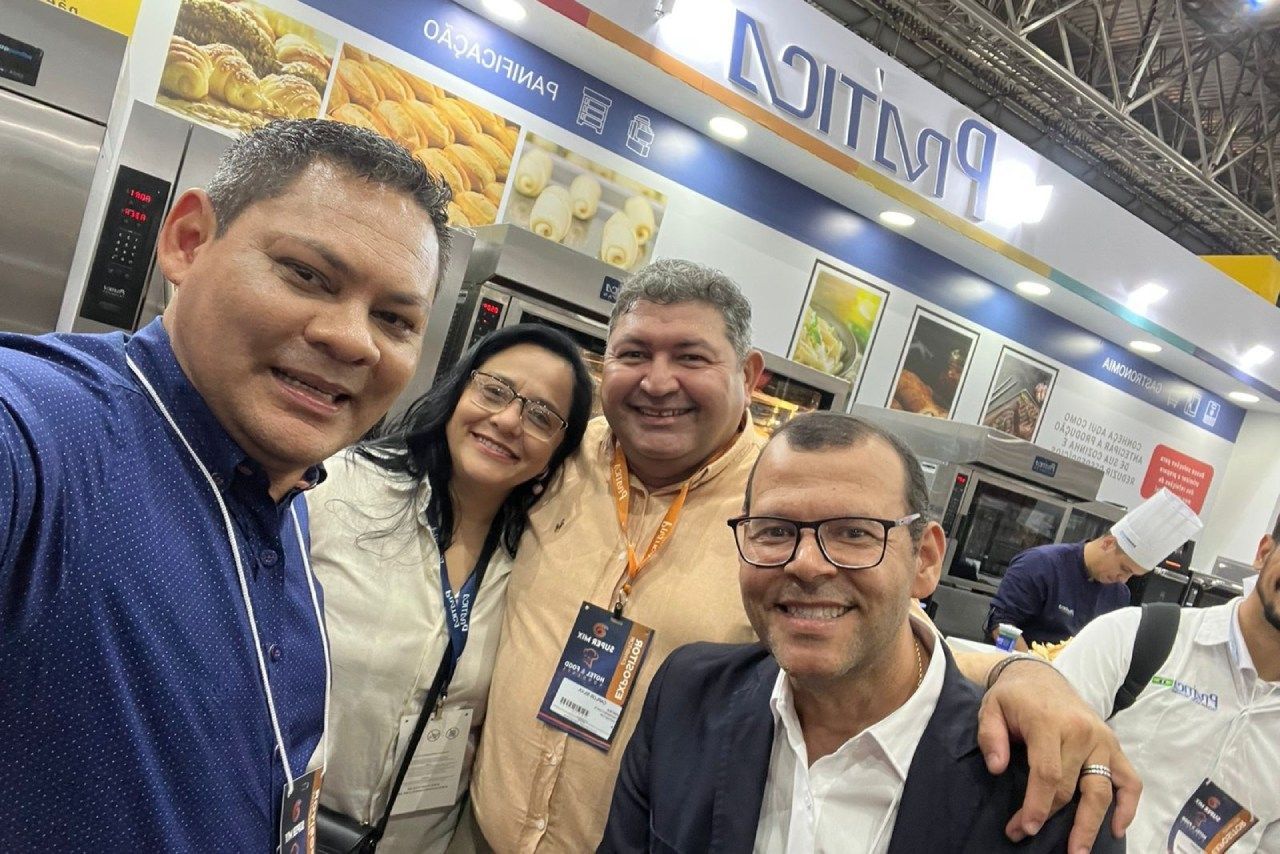 Um grupo de pessoas está posando para uma foto em frente a uma padaria.