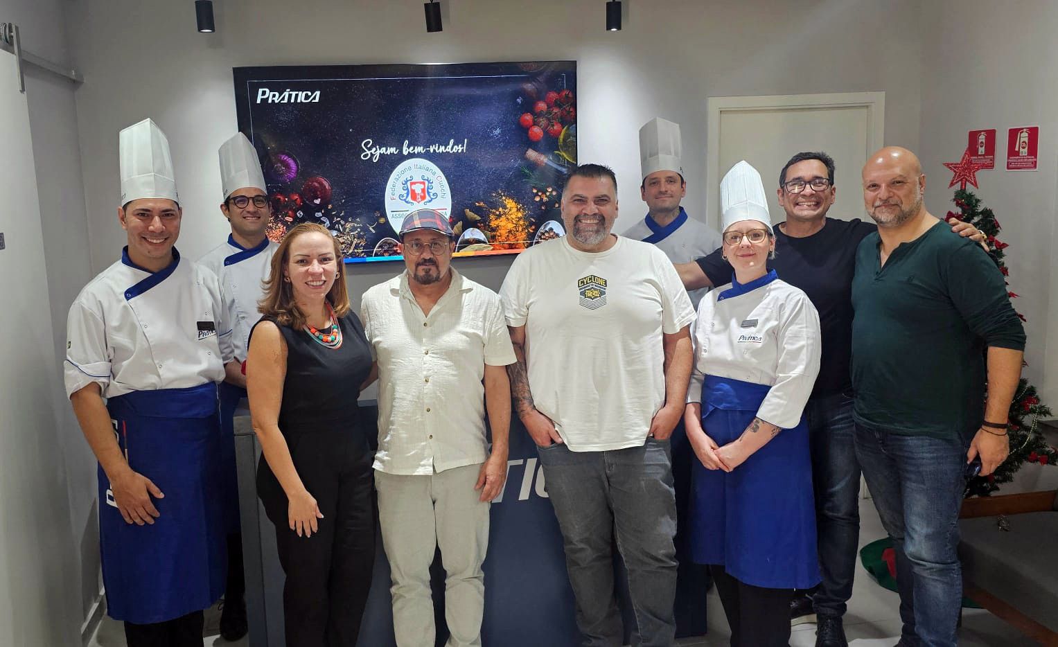 Um grupo de pessoas em pé, uma ao lado da outra, em uma sala.