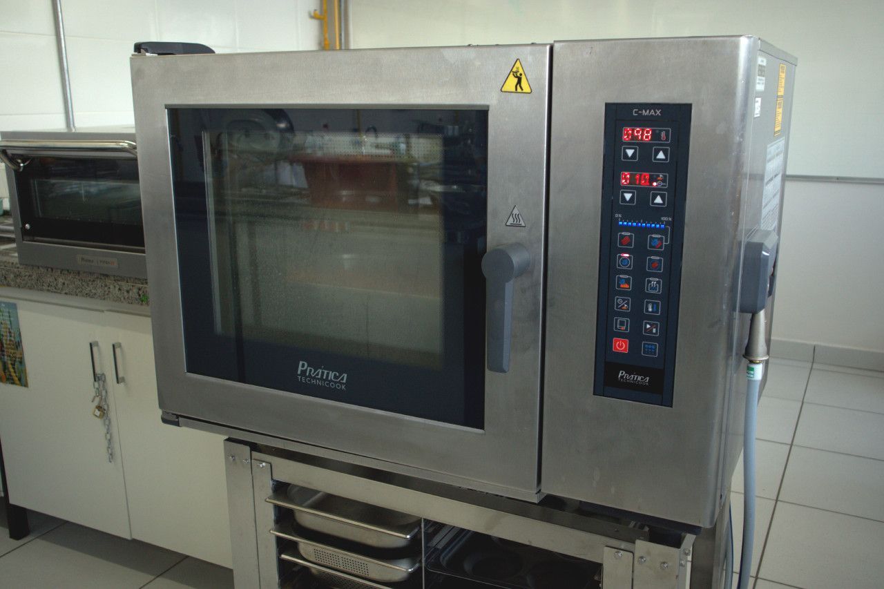 Um forno de aço inoxidável está sobre um balcão em uma cozinha.
