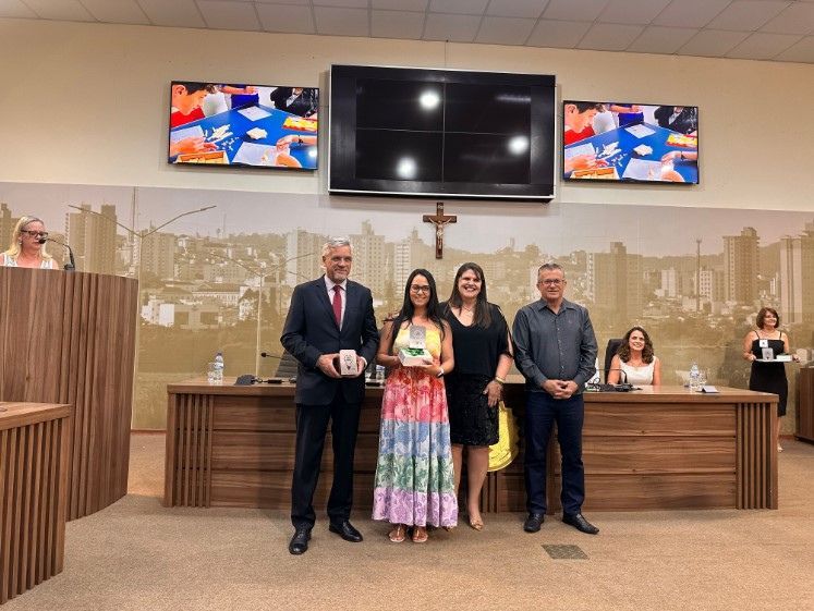 Um grupo de pessoas está posando para uma foto em uma sala de conferências.
