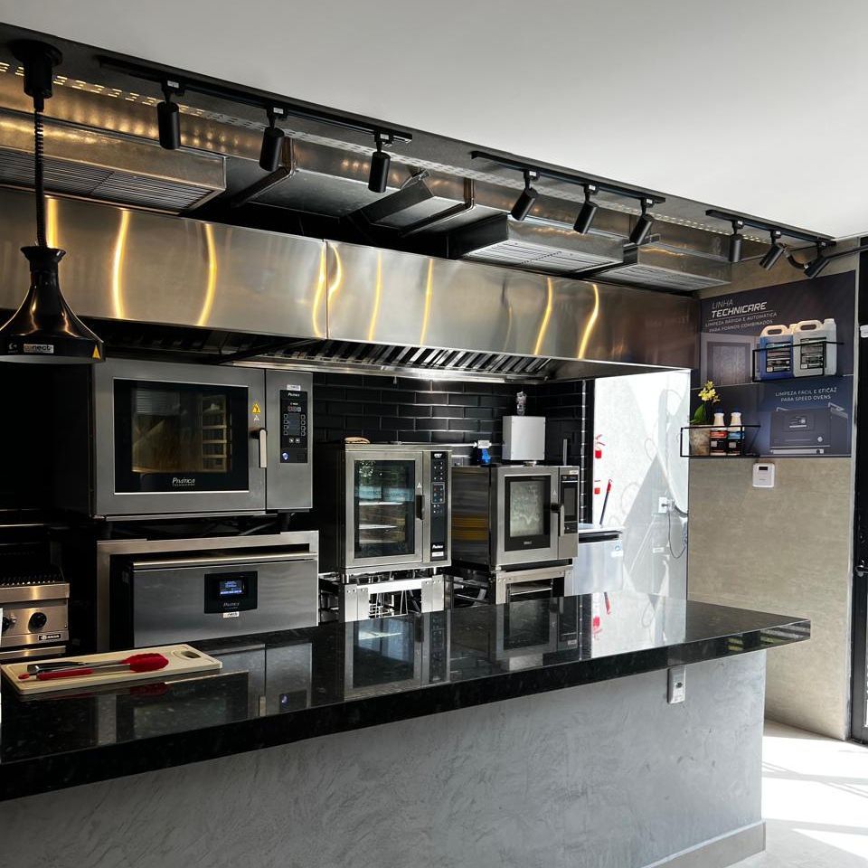 Uma cozinha com eletrodomésticos de aço inoxidável e uma bancada preta