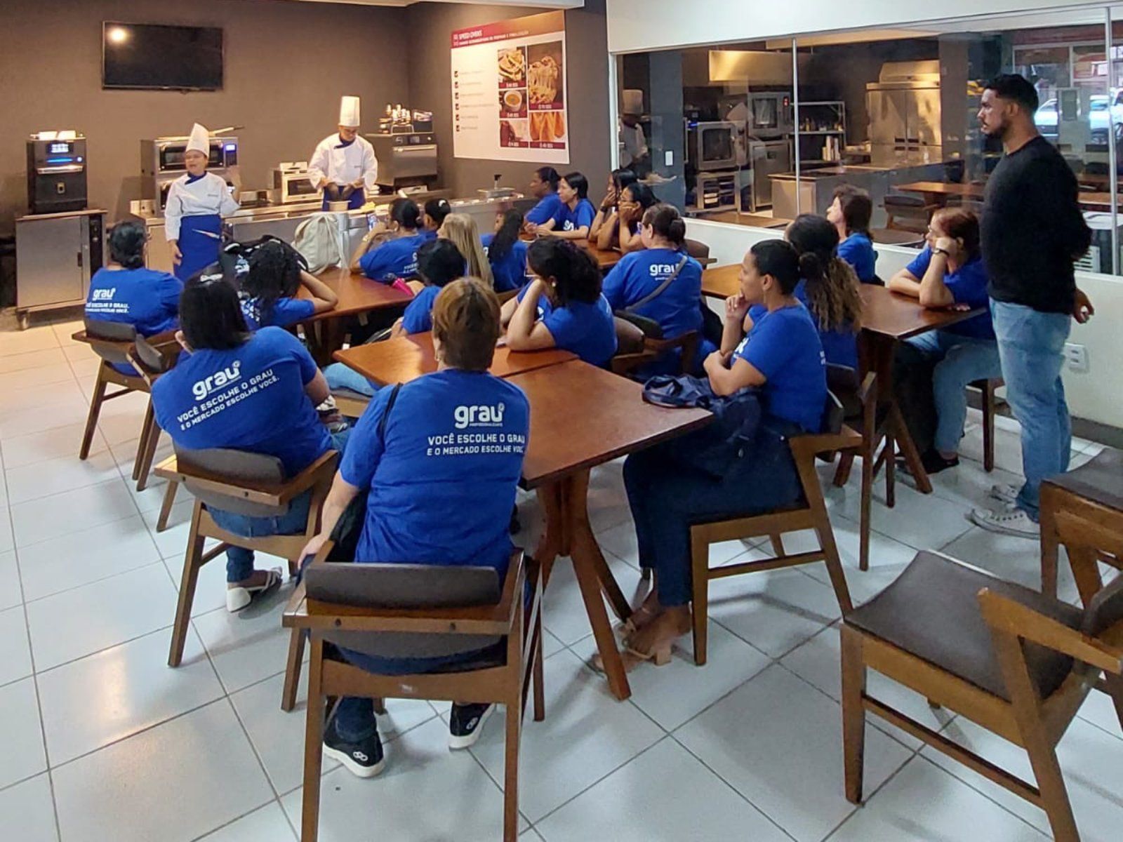 Um grupo de pessoas está sentado em mesas em um restaurante.